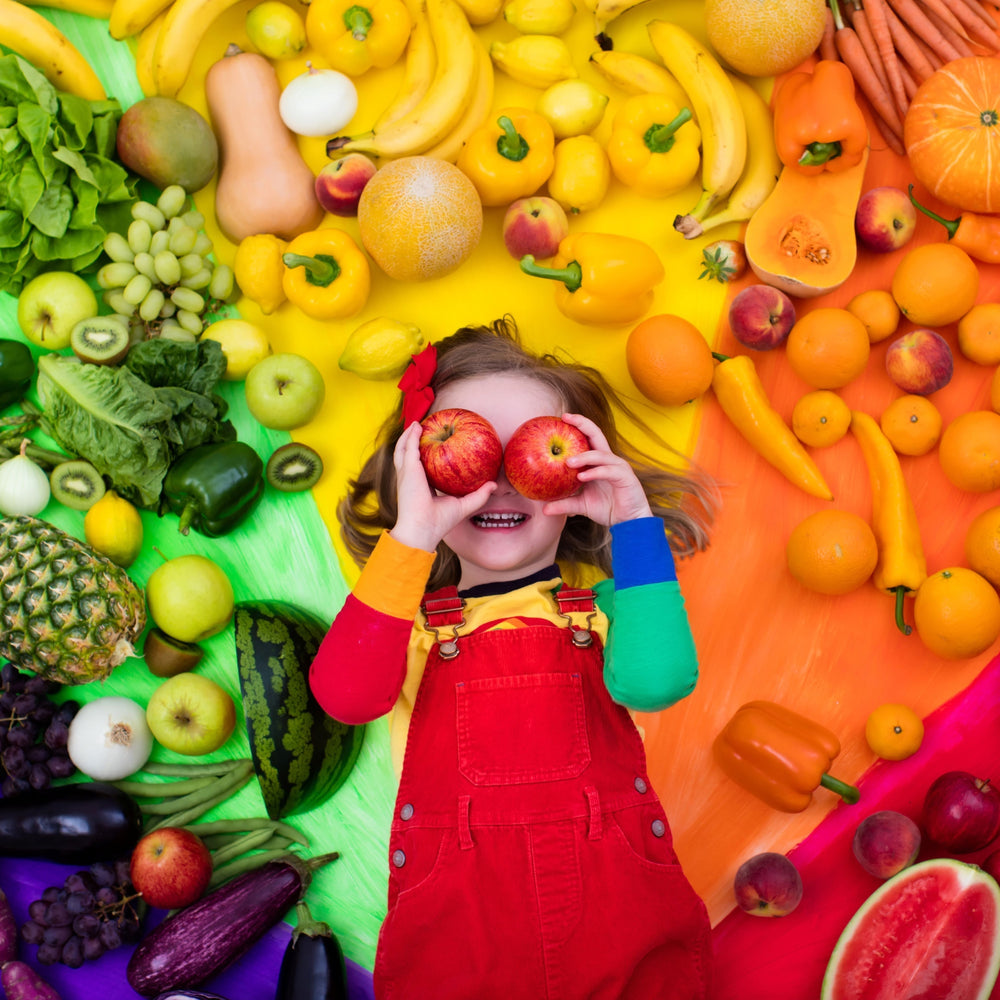 Girl with nutritious foods all around her
